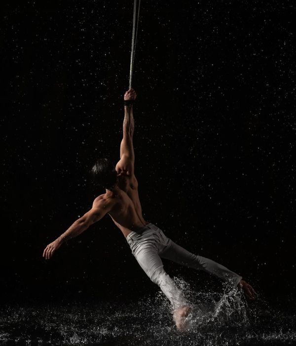 Man performing a controlled strength exercise in a dark room with cyan accents.